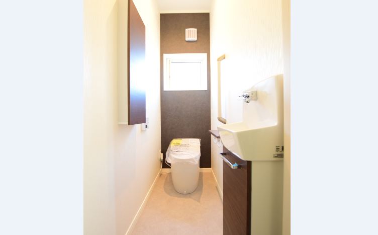 トイレはアクセントクロス、収納、手洗いの色を揃え<br/>
統一感のある空間を演出