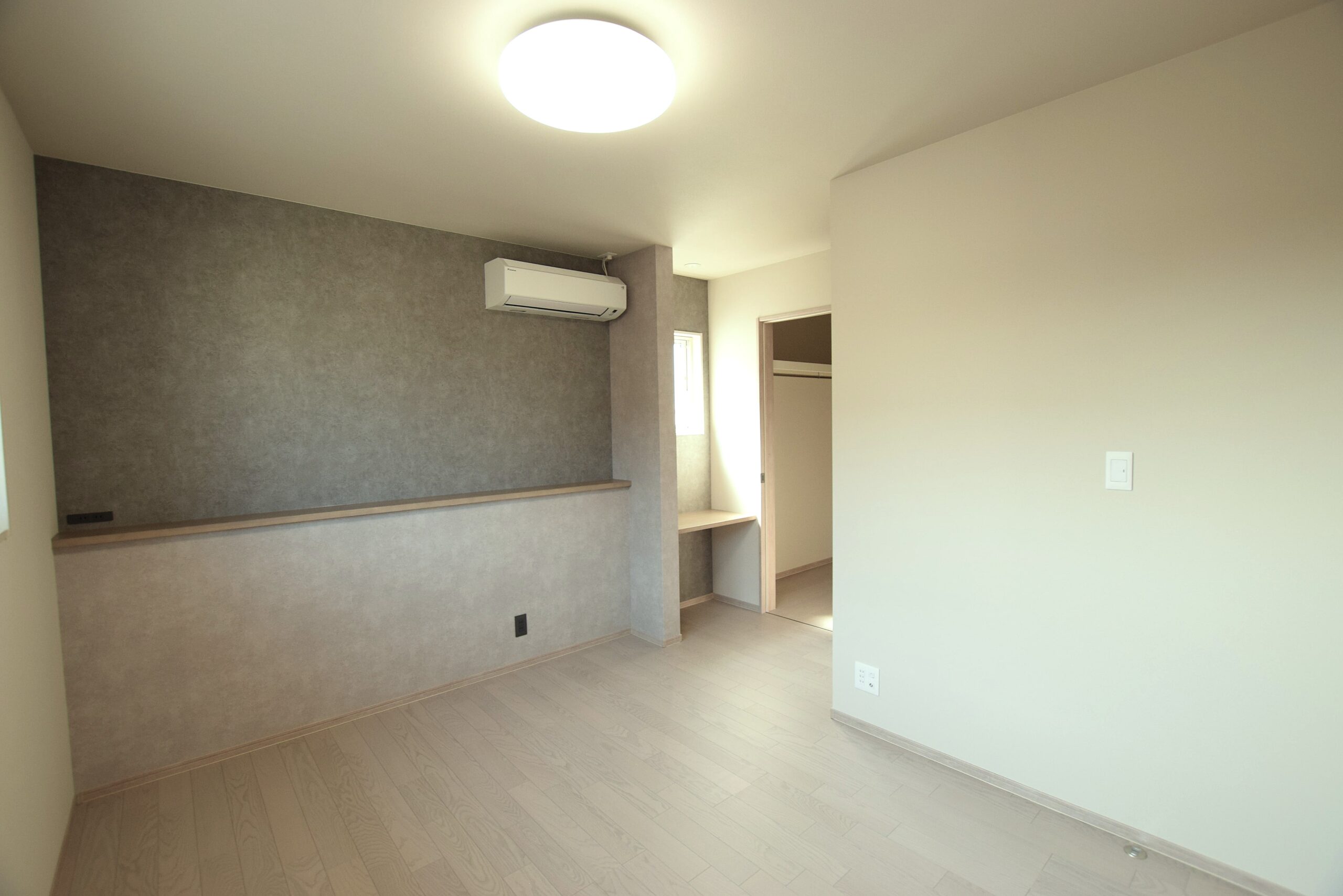 寝室のベッドの頭側に腰壁とカウンターを計画することで、ものを置くのにも便利。空間のアクセントにもなります。